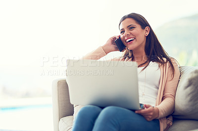 Buy stock photo Shot of a smiling young woman talking on the phone  andusing a laptop while relaxing on the sofa at home