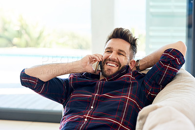 Buy stock photo Shot of a young man using his phone while relaxing on the sofa at home