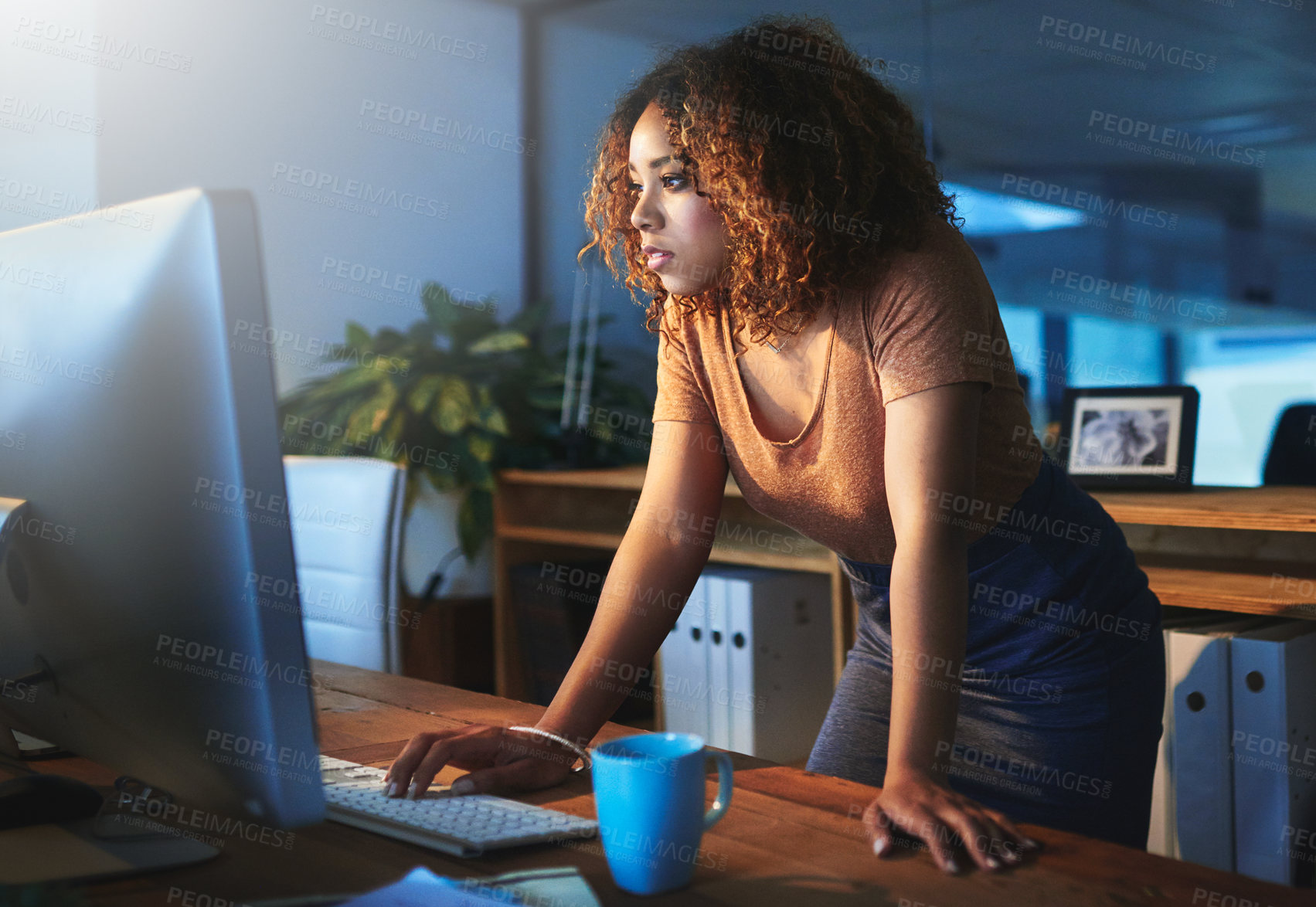 Buy stock photo Shot of a young woman working late in an empty office
