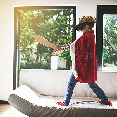 Buy stock photo Shot of a little boy in a king's costume playing with a vr headset on