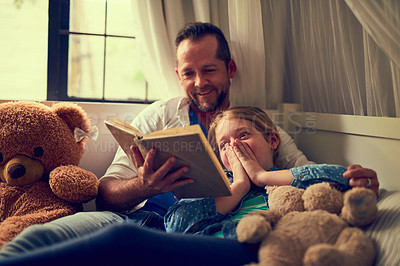 Buy stock photo Cropped shot of a father reading a story to his little daughter at home