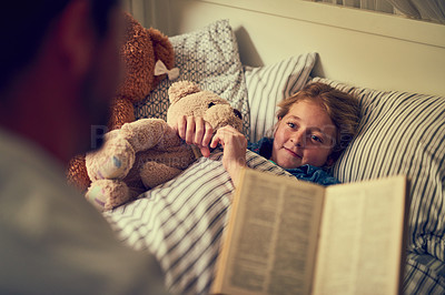 Buy stock photo Cropped shot of a father reading a bedtime story to his little daughter at home