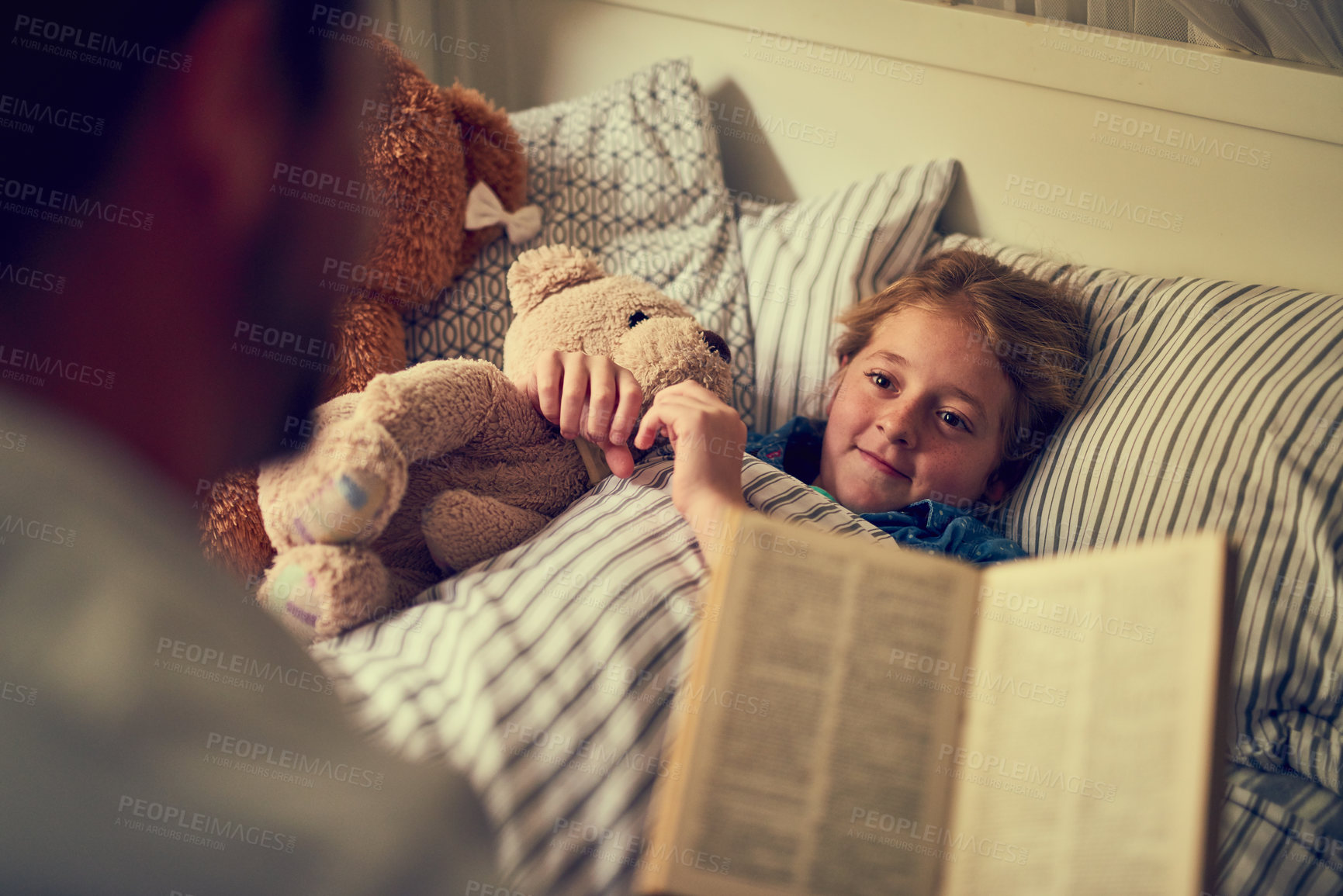 Buy stock photo Cropped shot of a father reading a bedtime story to his little daughter at home