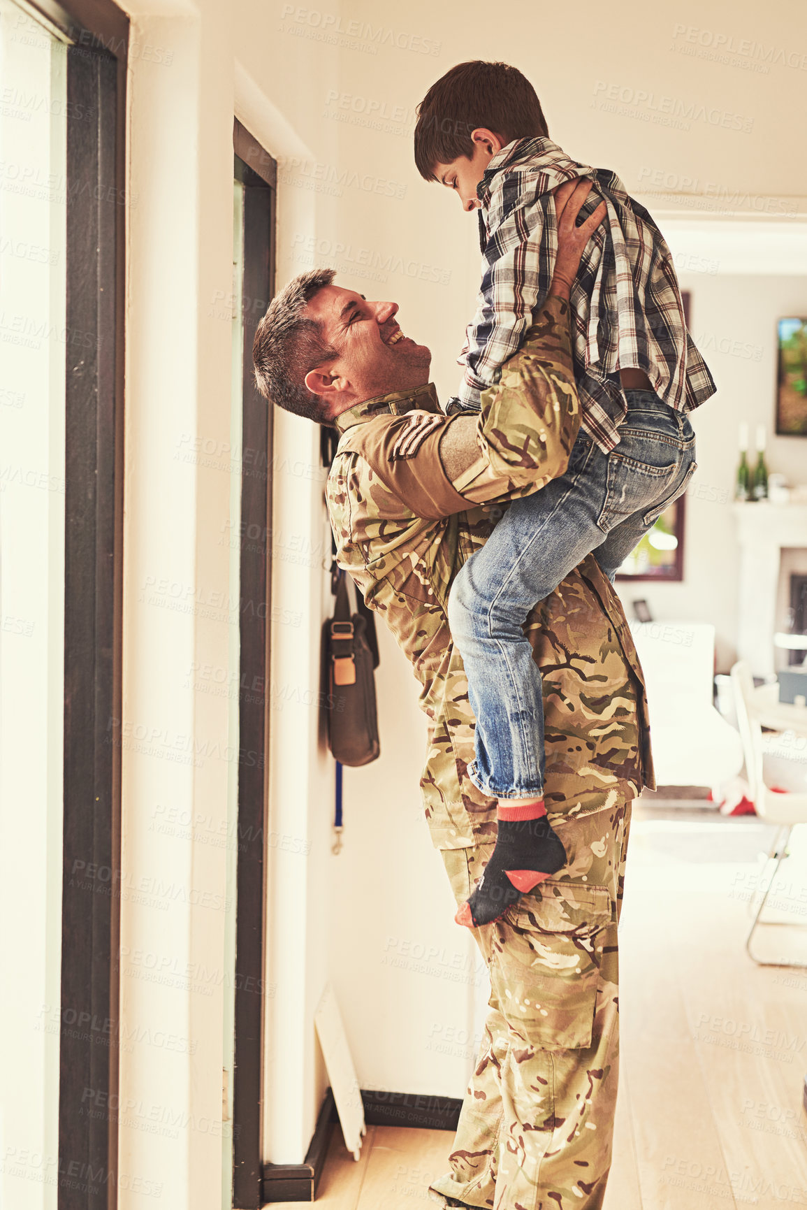 Buy stock photo Shot of a little boy welcoming his father home from the army