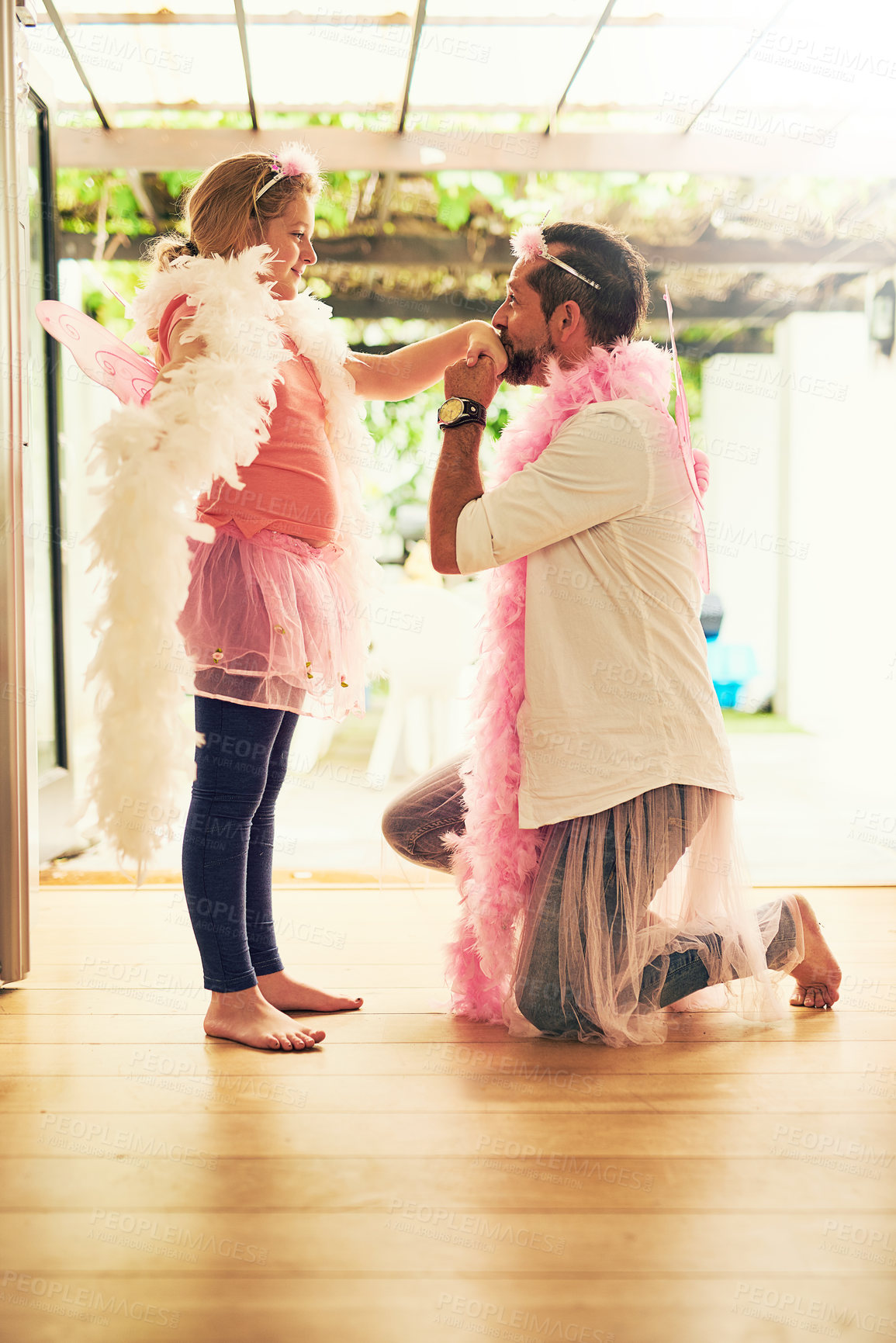 Buy stock photo Love, kiss or dad with princess or girl in family house or living room with pink costume, smile or parent. Hand, fairy or father with child, kid or wings for dress up, kneeling or games for promise