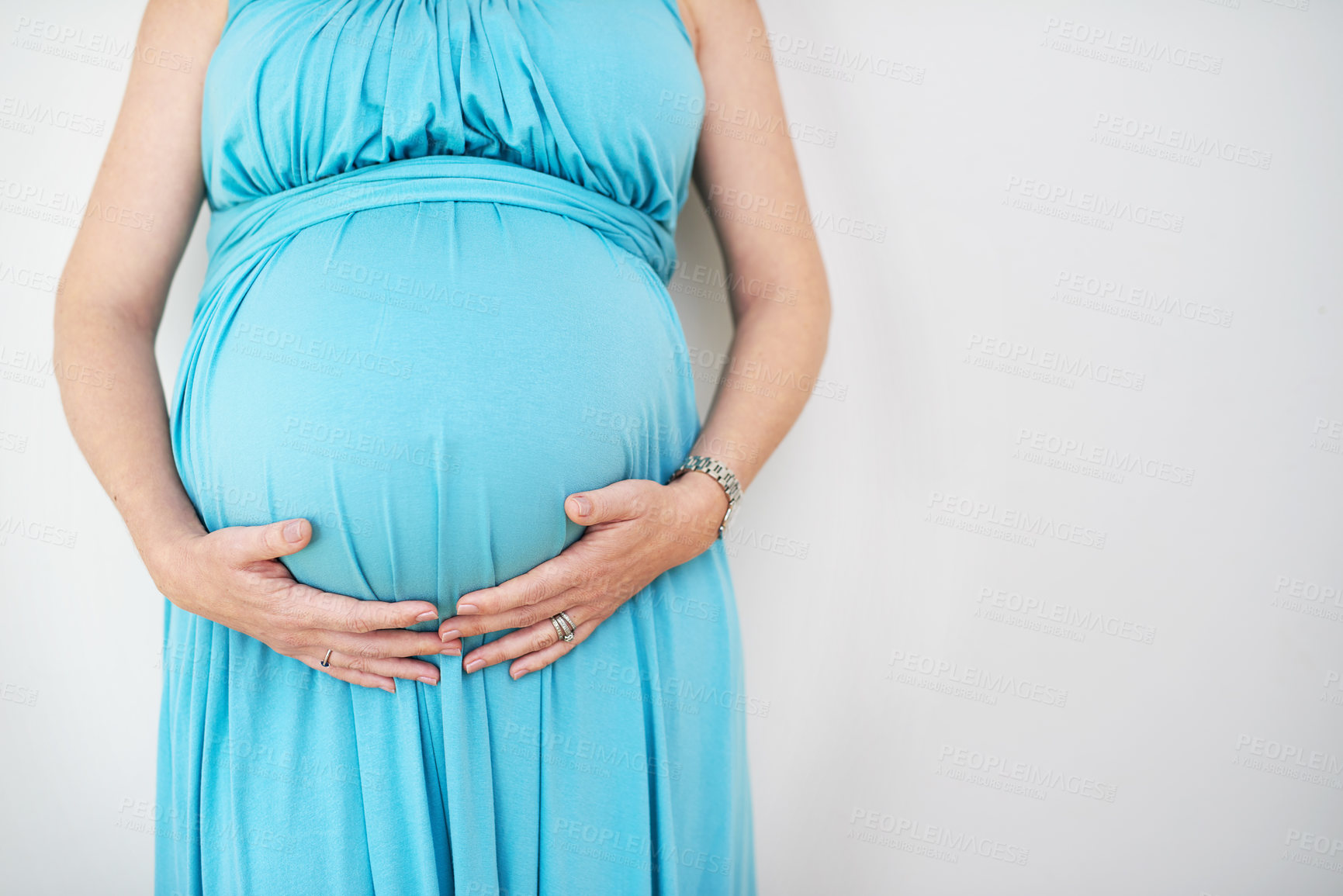 Buy stock photo Shot of an unidentifiable pregnant woman holding her belly against a white background