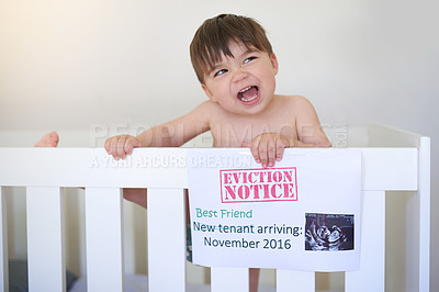 Buy stock photo Shot of an unhappy baby boy crying while standing in his crib