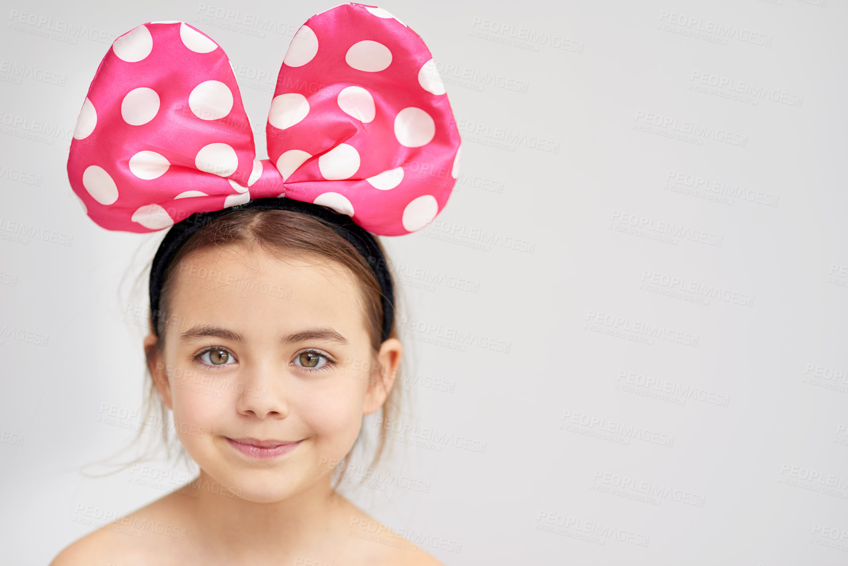 Buy stock photo Happy, young girl and pink bow in hair for party or event celebration with mockup isolated in studio. Smile, female child and alice band for trendy fashion and aesthetic accessory on white background