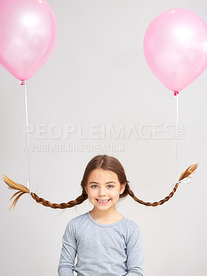 Buy stock photo Studio portrait of a cute little girl with balloons tied to her pigtails