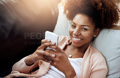 Buy stock photo Portrait of a relaxed young woman using her phone on the sofa at home