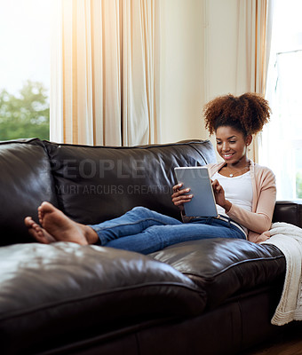 Buy stock photo Home, smile and black woman with tablet, typing or connection with online news, social media or digital app. African person, apartment or happy girl on sofa, tech or internet with lens flare or smile