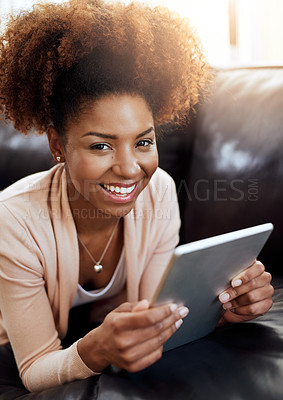 Buy stock photo Portrait of a relaxed young woman using a digital tablet on the sofa at home