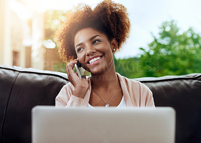 Buy stock photo Shot of a happy young woman using her phone and laptop on the sofa at home