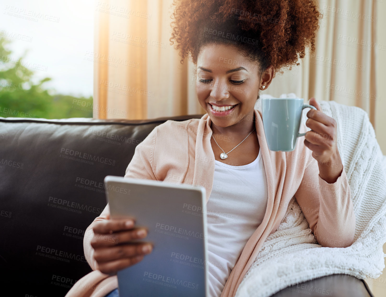 Buy stock photo Home, coffee and black woman with tablet, smile or connection with lens flare, relax or digital app. African person, apartment or happy girl on couch, tech or internet with tea, latte or social media