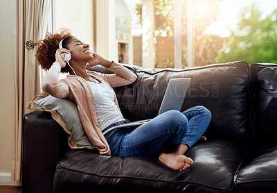 Buy stock photo Relax, laptop and woman on sofa with headphones, smile and happy morning streaming in living room. Rest, wellness and girl on couch in home with online music, digital app and computer in apartment.