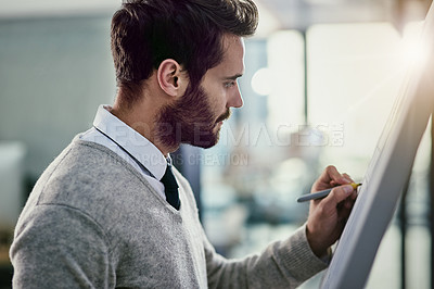 Buy stock photo Cropped shot of a young businessman writing on a whiteboard in an office