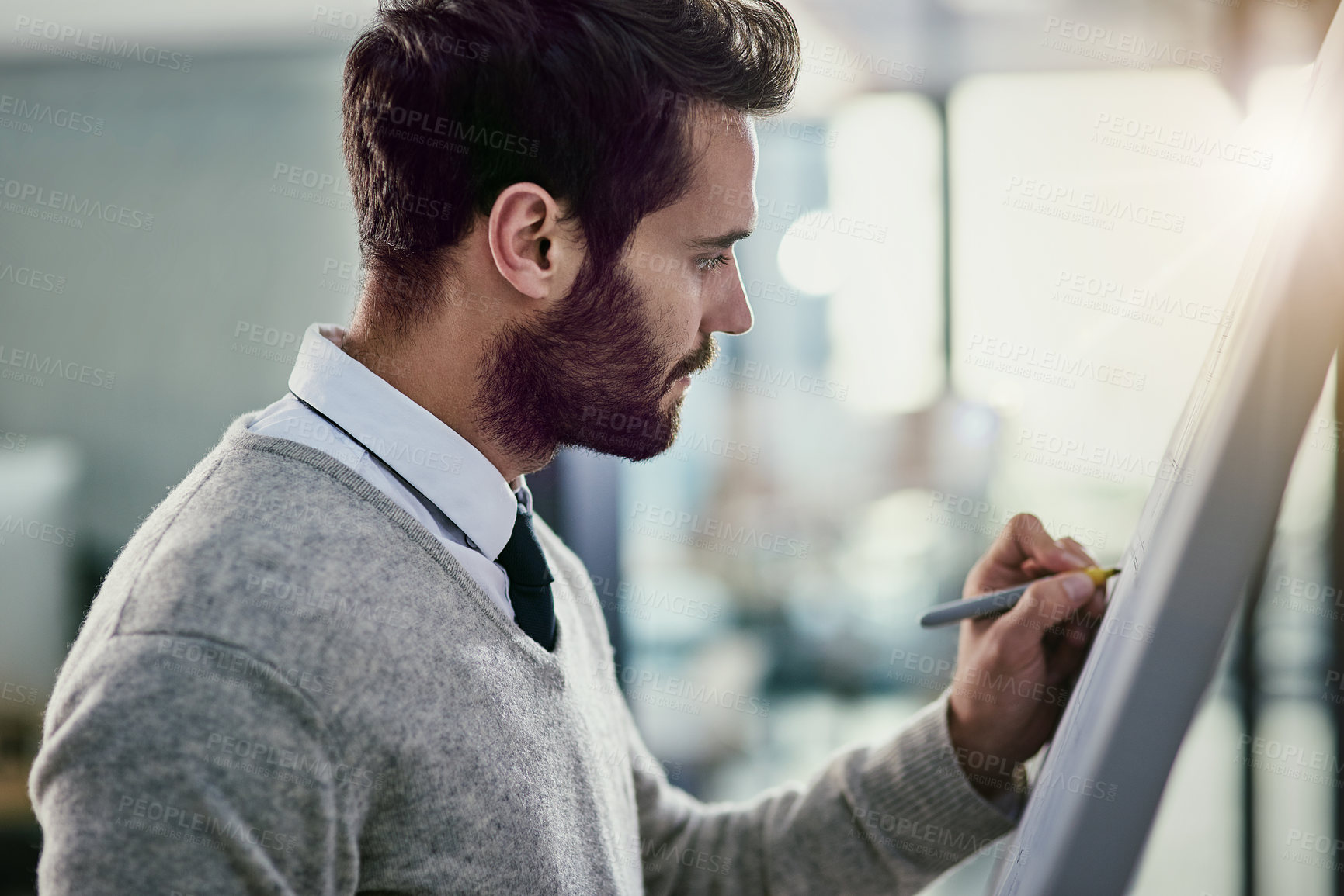 Buy stock photo Cropped shot of a young businessman writing on a whiteboard in an office