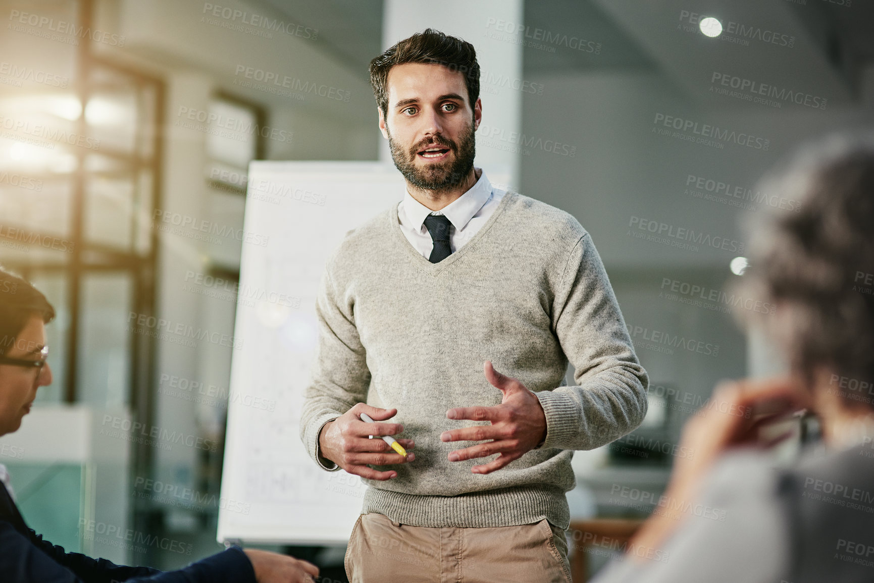 Buy stock photo Cropped shot of a young businessman giving a presentation to his colleagues in an office