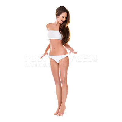 Buy stock photo Studio shot of a beautiful young brunette woman in a white bikini pulling on her waistband isolated on white