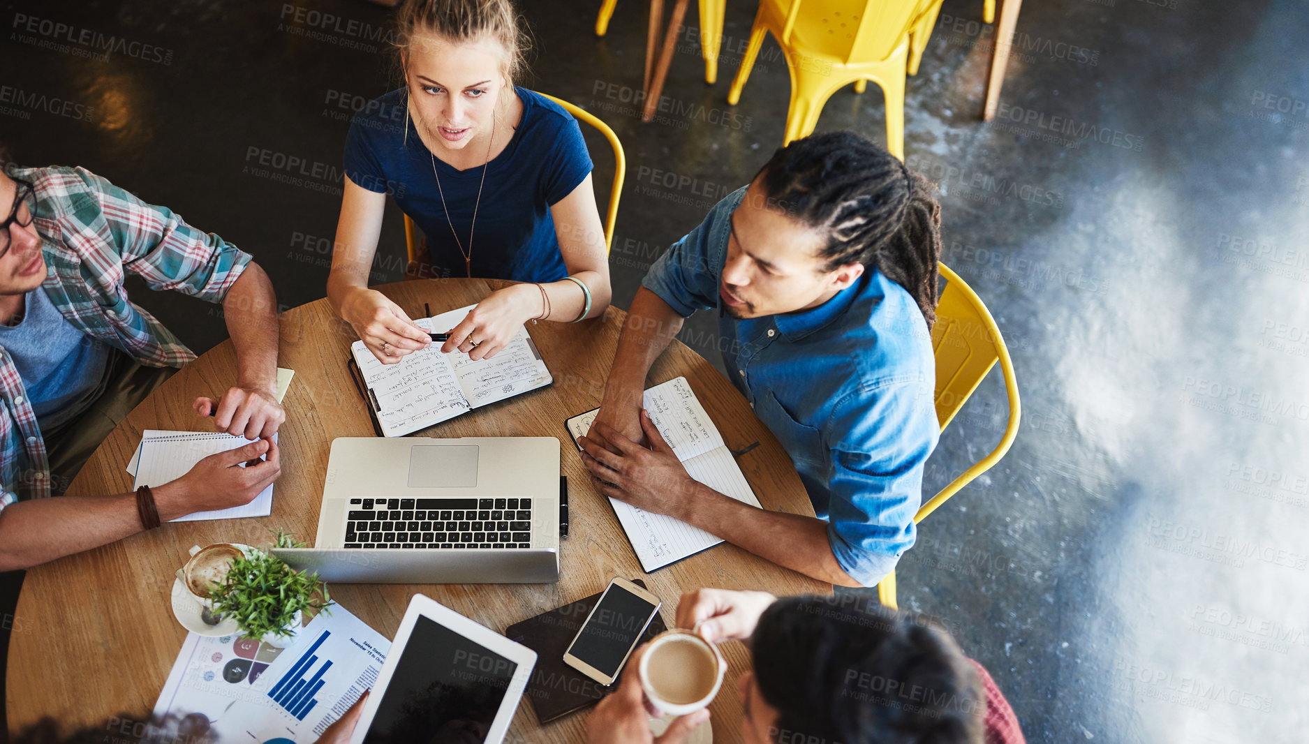 Buy stock photo High angle shot of a group of students studying in a coffee shop