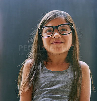 Buy stock photo Studio shot of a little girl wearing spectacles against a dark background