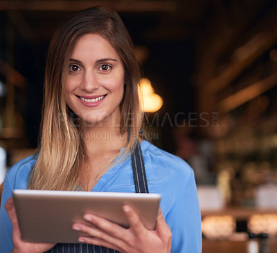 Buy stock photo Cropped portrait of an attractive young woman using a digital tablet in her coffee shop