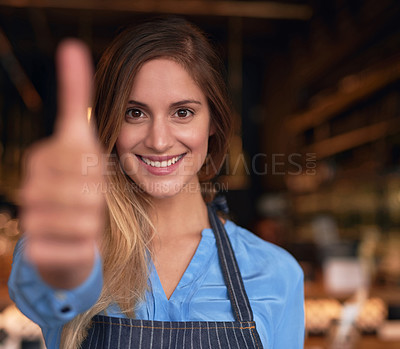 Buy stock photo Cropped portrait of an attractive young woman giving thumbs up while standing in her coffee shop