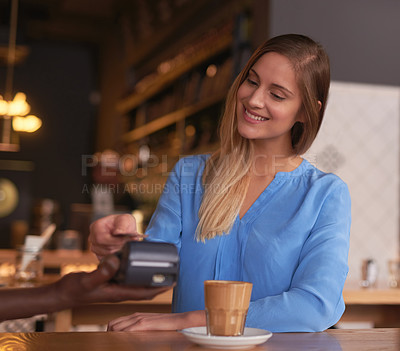Buy stock photo Cropped shot of an attractive young woman making payment in a coffee shop