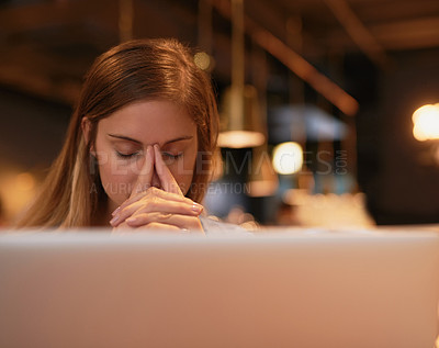 Buy stock photo Cropped sho of a young woman looking stressed while working in her local coffee shop