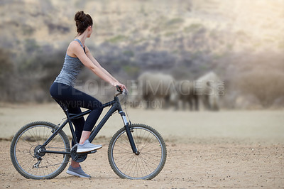 Buy stock photo Woman, bicycle and animal in Africa for adventure, nature and travel for cycling safari. Rhinoceros, wildlife and tourism or fitness for female person, holiday and game reserve in Savannah with bike