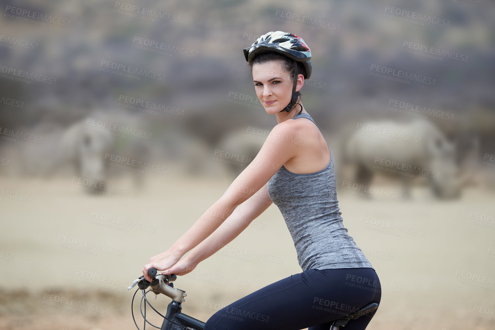 Buy stock photo Woman, bicycle and animal in Africa for adventure, nature and travel for cycling safari. Rhinoceros, portrait and tourism or fitness for female person, holiday and game reserve in Savannah with bike