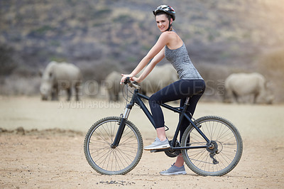 Buy stock photo Woman, bicycle and animal in Africa for adventure, nature and travel for cycling safari. Rhinoceros, portrait and tourism or fitness for female person, holiday and game reserve in Savannah with bike