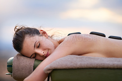 Buy stock photo Relax, massage and a woman lying in a spa for wellness treatment at a luxury resort while on vacation. Bed, zen or beauty salon and a female customer outdoor for stress relief with hot stone therapy