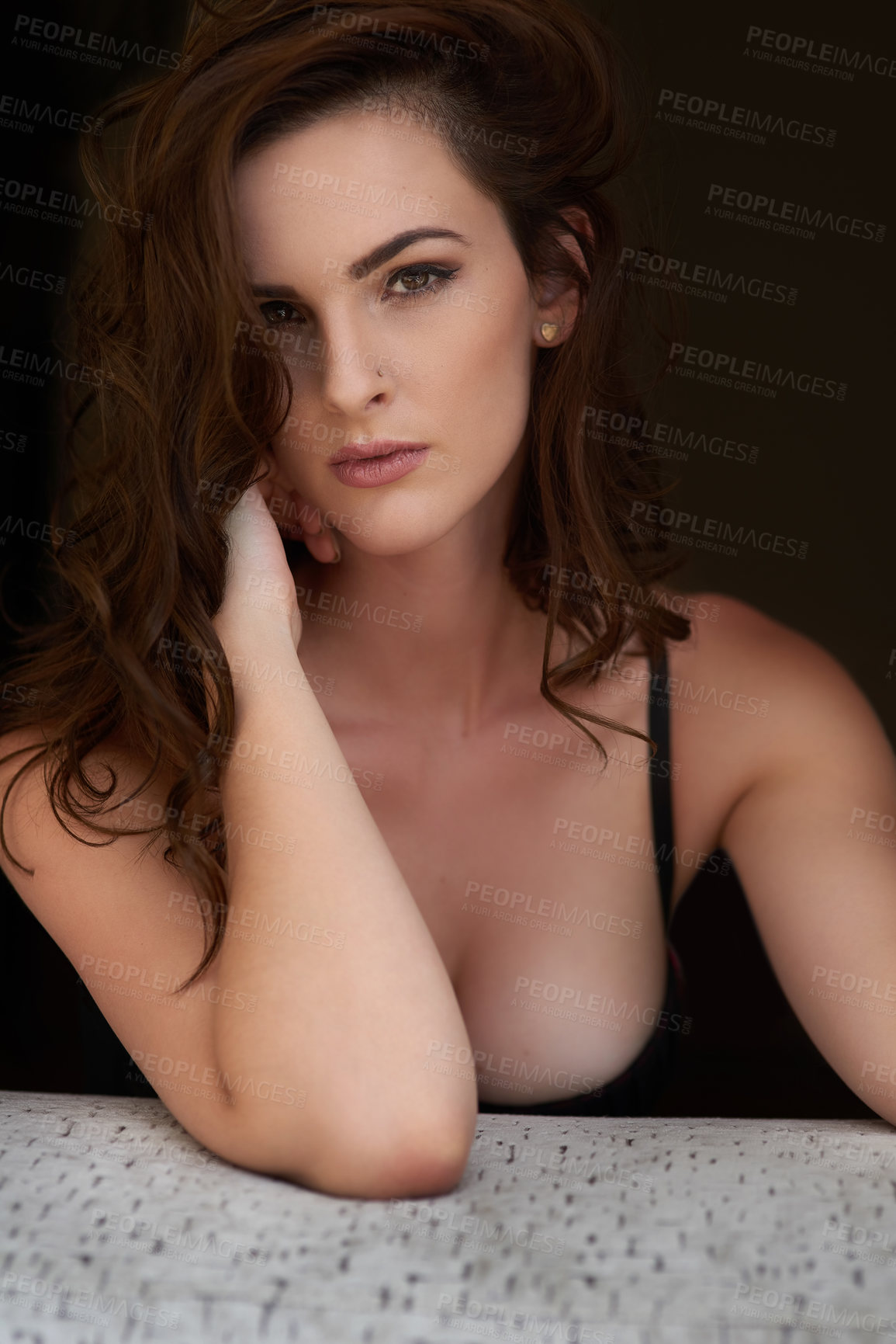 Buy stock photo Studio portrait of a sexy young woman posing seductively against a dark background