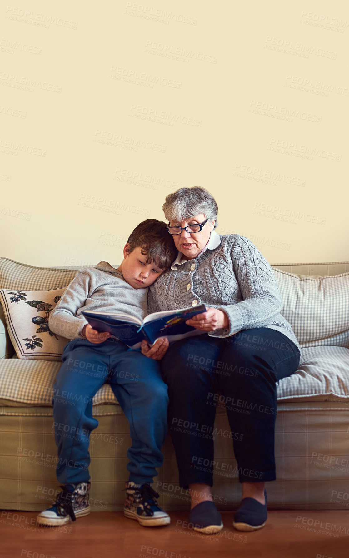 Buy stock photo Shot of a grandmother reading a book to her grandson at home