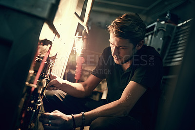 Buy stock photo Cropped shot of a handsome young man making some repairs indoors