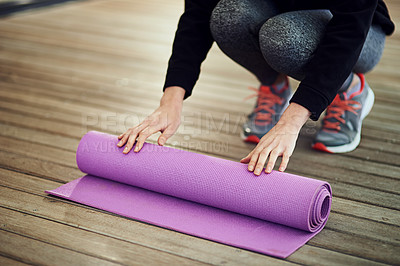 Buy stock photo Cropped shot of an unrecognizable woman rolling her mat up after yoga