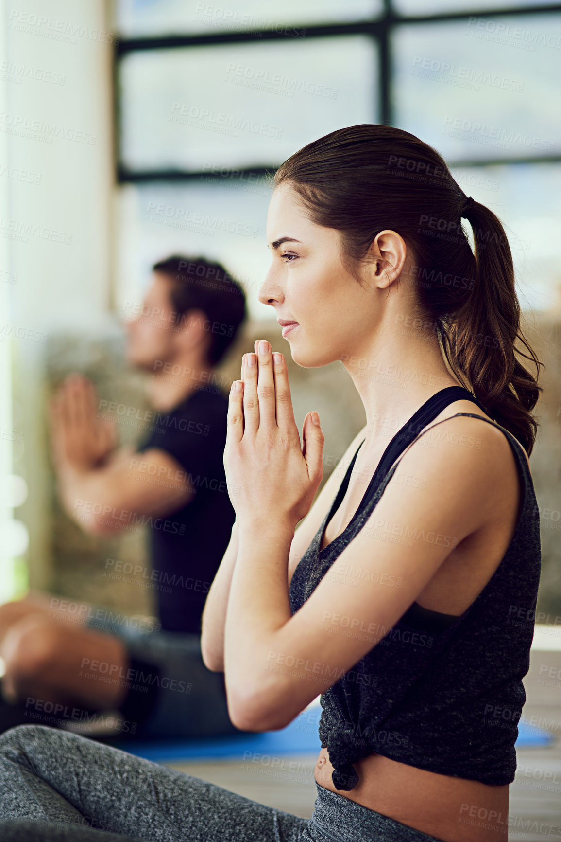 Buy stock photo Cropped shot of two young people practising yoga indoors