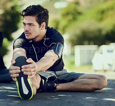 Buy stock photo Full length shot of a handsome young man warming up outdoors before a workout