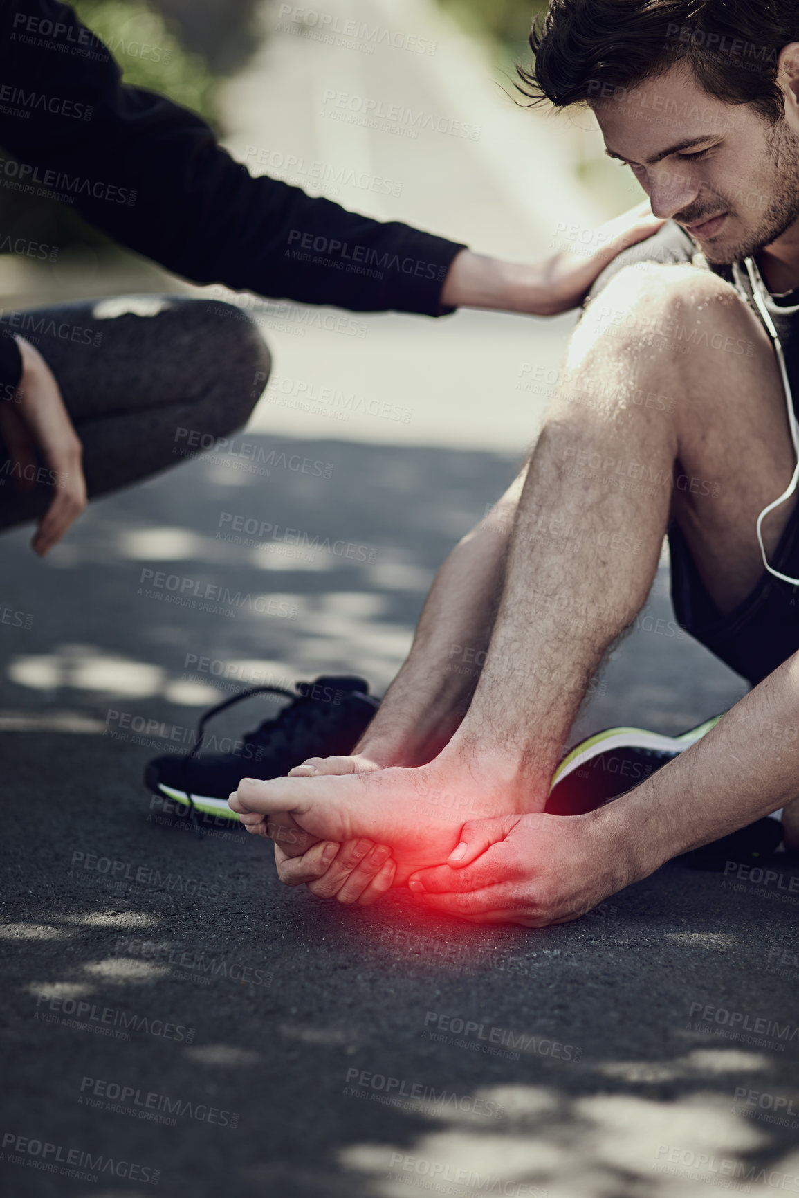 Buy stock photo Cropped shot of a young man suffering with foot cramp during a run