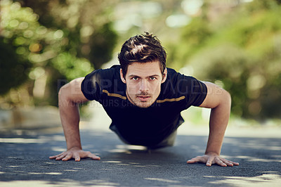 Buy stock photo Full length portrait of a handsome young man doing pushups outdoors