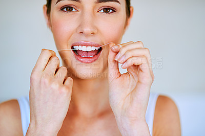 Buy stock photo Cropped shot of a beautiful young woman flossing her teeth