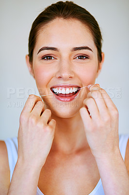 Buy stock photo Cropped shot of a beautiful young woman flossing her teeth