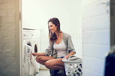 Buy stock photo Cropped shot of a young woman doing laundry at home