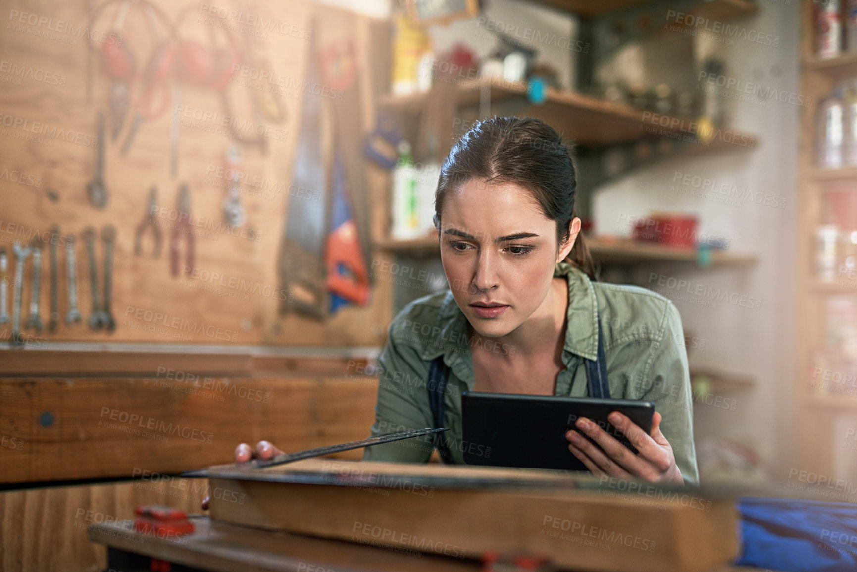 Buy stock photo Woman, carpenter and measuring with builders square and tablet for planning and wood working in workshop. Female person, engineer and thinking with tech for furniture idea, manufacturing and contact