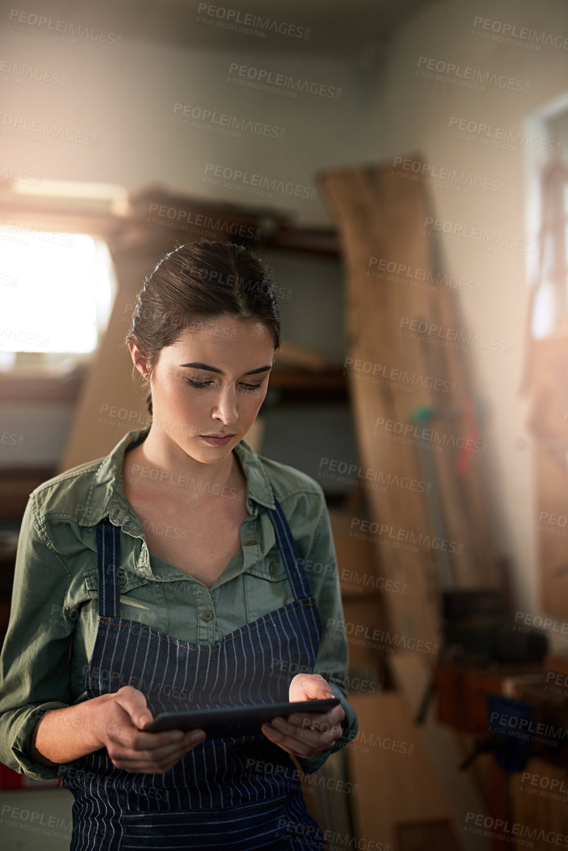 Buy stock photo Woman, carpenter and digital tablet in workshop for planning, online inspiration and ideas with tech. Woodworker, girl and research for manufacturing, creative design and information with scroll