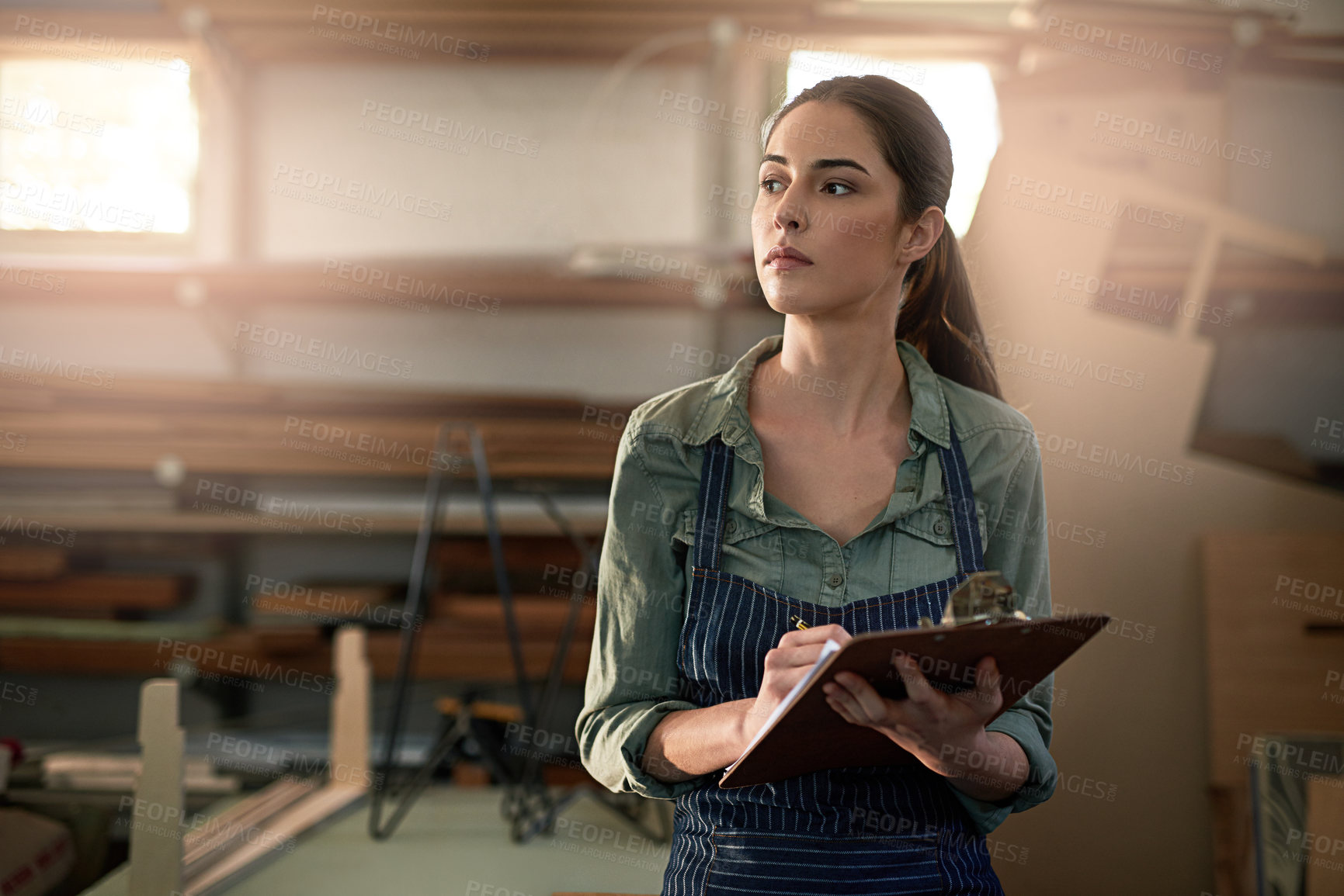 Buy stock photo Craft, woman and clipboard in workshop for planning, thinking and stock inspection. Carpenter, girl and paper for maintenance, product checklist and manufacturing inventory in factory for woodworker