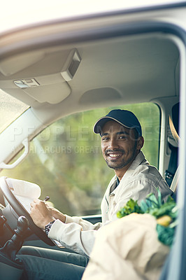 Buy stock photo Portrait of a delivery man writing on a clipboard while sitting in his van