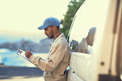 Buy stock photo Cropped shot of a delivery man writing on a clipboard while standing next to his van