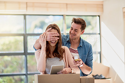 Buy stock photo Cropped shot of a young man surprising his girlfriend by proposing while moving house